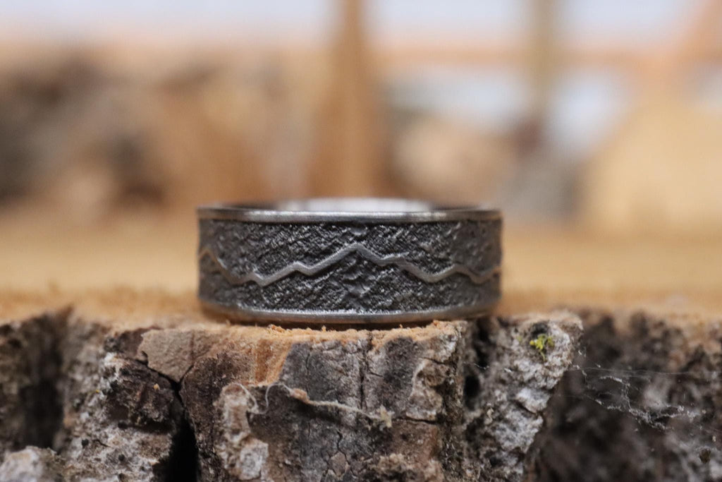 Handcrafted titanium ring with a rugged mountain range design, inspired by the Rockies. 'The Rocky Ridge' symbolizes strength and adventure, perfect for outdoor enthusiasts. A unique statement piece for those who love nature and the great outdoors.
