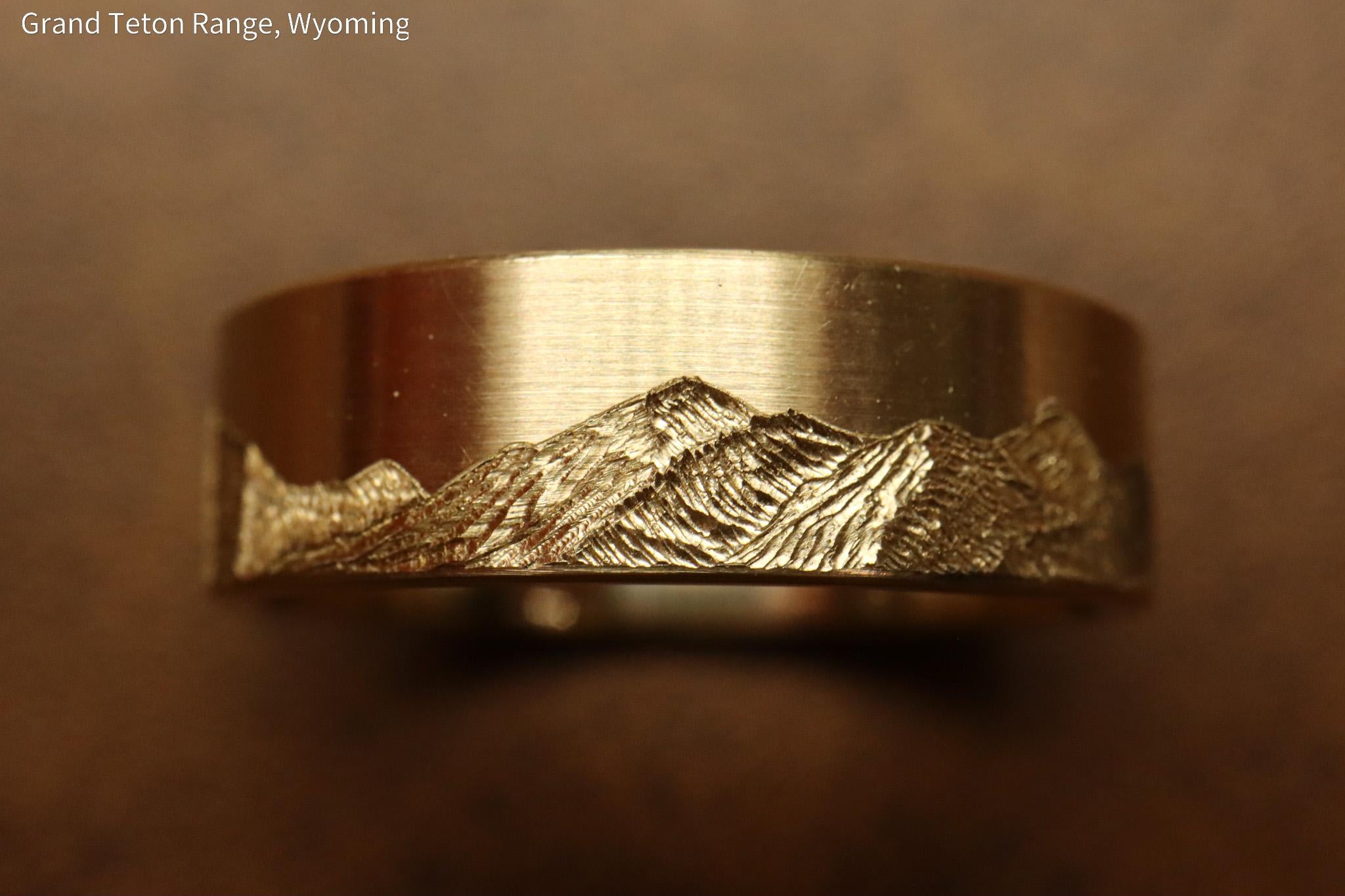 Grand teton mountain range, hand carved on to 14k Yellow gold ring. 6mm wide with comfort fit profile